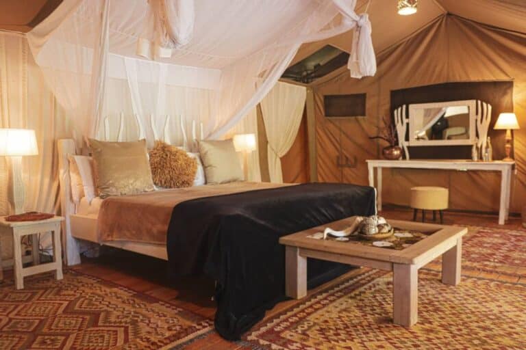 Double tent with a four-poster bed at Mara Crossing Luxury Camp