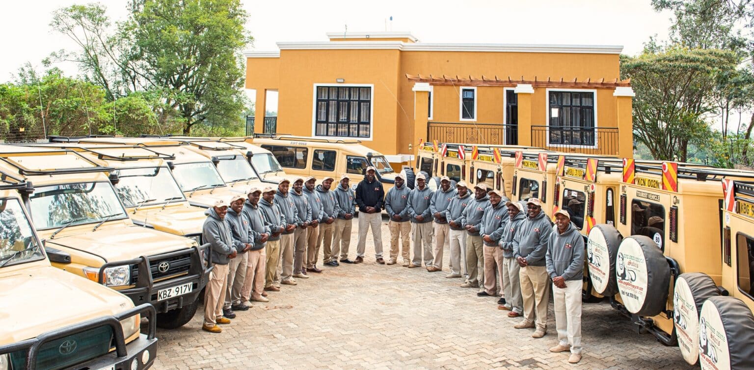 The Explorer Kenya driver-guide team standing in front of their safari Land Cruisers